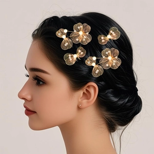 Detailed close-up of golden wire mesh floral hairpins with white pearls and sparkling crystals