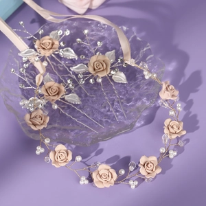 Close-up of handmade pink fabric flower hair accessory set with pearls and silver leaves