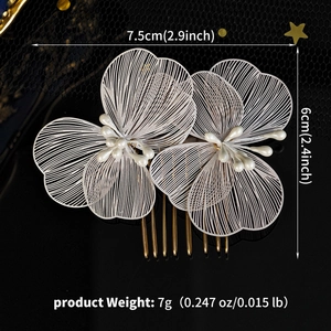 Detail view of hollow white metal flower petals with central pearl bead on gold hair comb