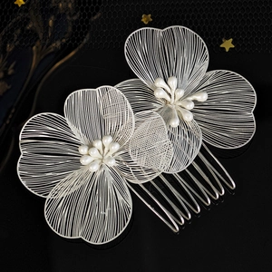 Detailed macro view of silver wire floral hair combs with delicate white pearl embellishments