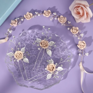 Detailed shot of pink clay flower hairpiece set with pearls and silver leaves for weddings