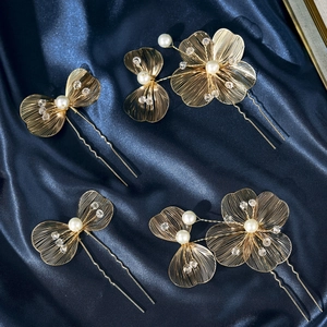 Detail of five-piece gold wire floral hairpins with pearls and crystals on blue silk