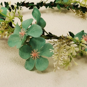 Detailed macro view of mint green and pink floral wreath headband with delicate petals