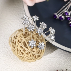 Detailed macro view of silver flower hair pins with sparkling rhinestone centers and petals