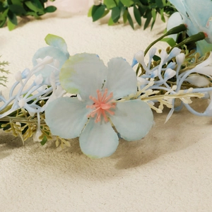 Detail of light blue faux flowers and orange stamens for wedding headband