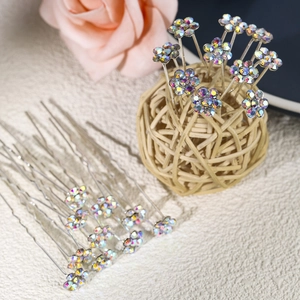 Detailed close-up of U-shaped bridal hair pins with iridescent rhinestone flower design