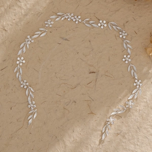 Macro view of silver bridal hair vine with rhinestone flowers and pearl accents
