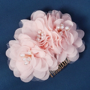 Détail d'un peigne à cheveux avec fleurs en tulle rose, perles et métal doré