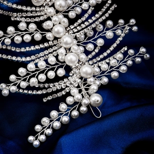 Detailed close-up of handmade bridal headband with sparkling rhinestones and white pearls