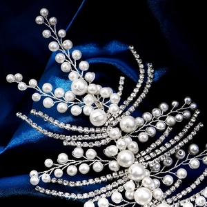 Close-up of handmade bridal headband with pearls and rhinestones on blue satin fabric