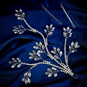 Detail of leaf-shaped bridal hair vine with silver crystals on dark blue silk fabric
