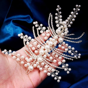 Close-up of handmade bridal headband with white pearls, crystals and silver wire