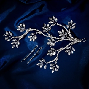 Detailed bridal hair vine set with crystal leaves and pins on deep blue silk background