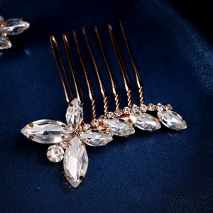 Detailaufnahme des goldenen Brauthaarkamms mit Kristallen und Perlen auf blauer Seide