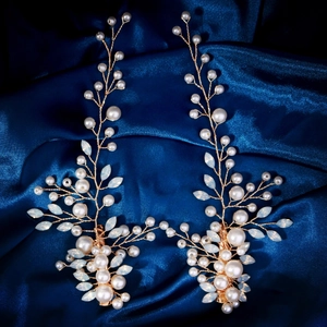 Barrettes à cheveux perles et feuilles de plumes sur fond élégant en satin bleu marine
