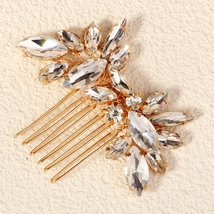Detailed close-up of golden bridal hair comb with marquise and round rhinestones