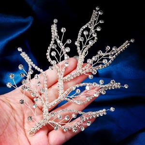 Detailed macro view of handcrafted silver leaf-shaped bridal hairpiece with sparkling rhinestones