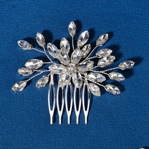 Detailed shot of silver bridal hair comb with marquise rhinestones on blue background
