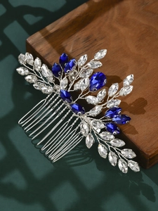 Detail of silver alloy bridal hair comb with blue rhinestones on a dark wooden tray