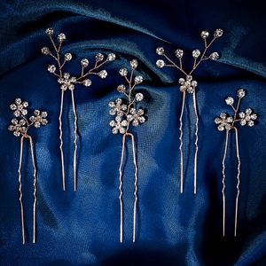Set of five rose gold bridal hair pins with clear rhinestones on dark blue silk
