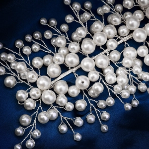 Détail d'un serre-tête de mariée en fil d'argent avec perles blanches sur soie bleue