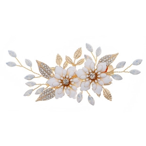 Detail of handcrafted white flower hair clips with gold alloy leaves and pearl beads