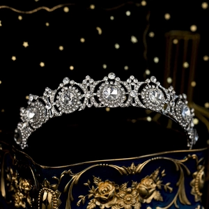 Close-up of a silver bridal crown with intricate rhinestones on a vintage gift box