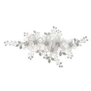 Detail view of handmade bridal hair accessory with white fabric flowers and pearls
