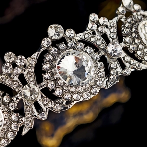 Macro detail of silver bridal crown with sparkling rhinestones on black background