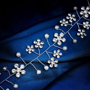 Detail of handmade bridal hair vine featuring rhinestone plum flowers and white pearls