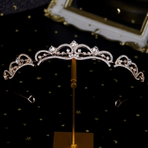 Détail de la couronne en or rose avec cristaux blancs sur fond noir étoilé élégant