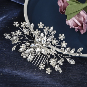 Detail of silver bridal hair comb with marquise rhinestones and pearls on blue velvet