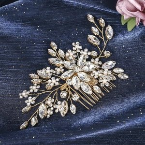 Detail of luxury bridal hair comb with marquise rhinestones and white pearls on gold wire