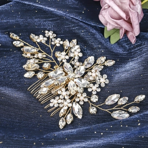 Detailed close-up of bridal gold hair comb with sparkling crystals and white pearls