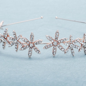 Dettaglio della tiara in oro rosa con motivi floreali e strass bianchi brillanti
