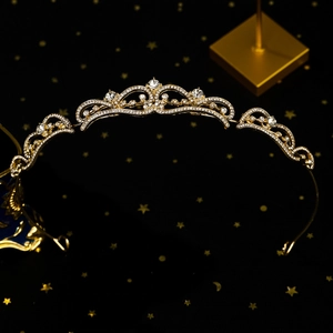 Détail d'une élégante tiare de mariée dorée avec strass scintillants et pierres blanches