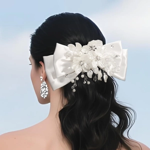 Détail d'un nœud papillon en satin blanc avec fleurs en tissu, perles et cristaux