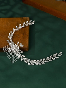 Detail of silver bridal hair comb featuring leaf vines and shimmering rhinestones