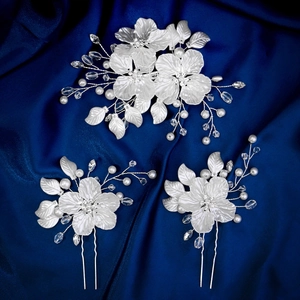 Détail de bijoux de cheveux de mariée avec fleurs en résine blanche et perles