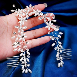 Macro detail of handmade bridal hair vine with silver wire, white pearls and crystal leaves