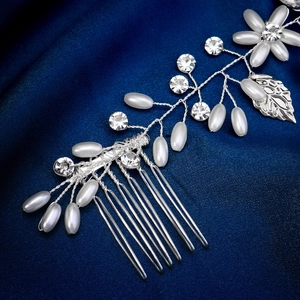 Detailed view of handmade bridal hair comb with white pearls and sparkling rhinestones