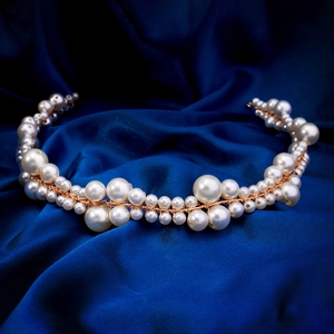 Elegant handmade pearl headband with white beads on deep blue satin background