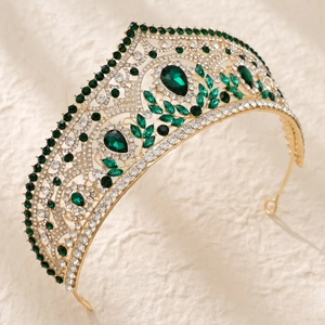 Detailed side view of luxury bridal crown with emerald green gems and white crystals