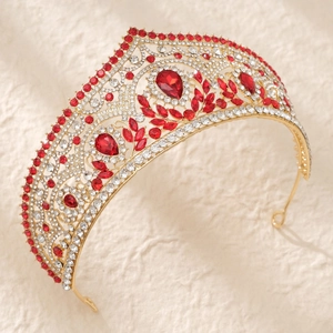 Detailed close-up showing red pear-shaped rhinestones on a golden vintage bridal crown