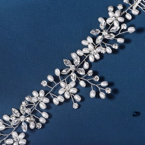 Close-up of handmade bridal headband with white pearls and sparkling crystal flowers