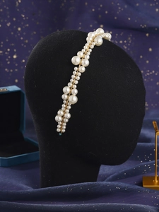 Macro detail of hand-woven pearl headband with golden wires for bridal hairstyle