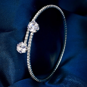 Close-up of sparkling rhinestone open bracelet with two large crystals on blue satin