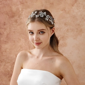 Dettaglio della fascia da sposa con foglie d'argento e cristalli su una modella