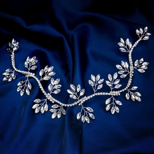 Vite per capelli da sposa in argento con foglie di cristallo su sfondo di raso blu scuro
