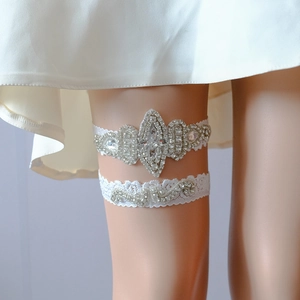 Detailed macro view of white bridal lace garters with luxury hand-stitched rhinestones